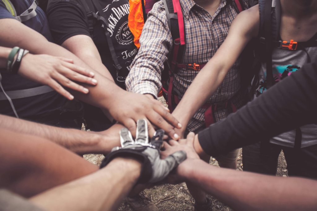 pexels photo 3280130 3280130 A group of diverse individuals join hands for teamwork in West Java, Indonesia.