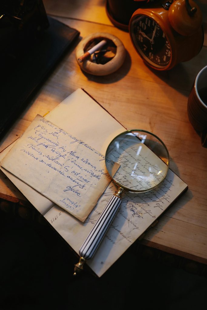 pexels photo 6980888 6980888 A cozy vintage setup featuring a magnifying glass, letters, and an old clock on a wooden desk.